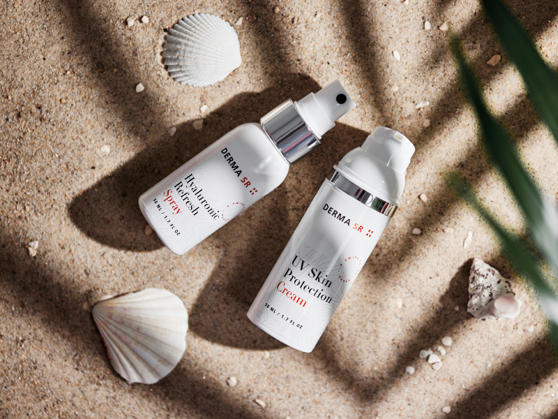 Deux produits de soin de la peau sont posés sur le sable de la plage
